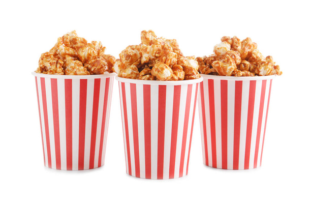 Tazze con gustosi popcorn al caramello su sfondo bianco
 - Foto, immagini