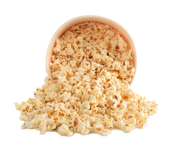 Overturned cup with tasty popcorn on white background - Foto, imagen