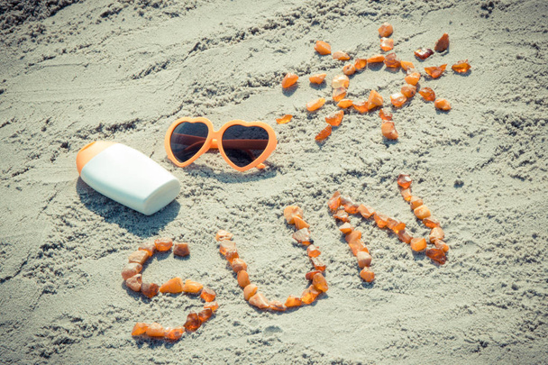 Vintage photo, Word and shape of sun, sunglasses with sun lotion at beach, summer time - Fotoğraf, Görsel