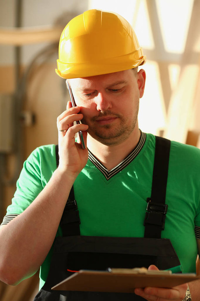 Плотник разговаривает по телефону в хозяйственном магазине - Фото, изображение