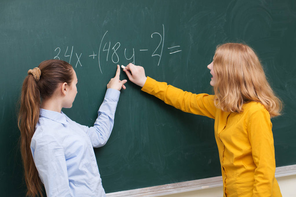 Δύο κορίτσια στο μαυροπίνακα σε μια κλάση μαθηματικών - Φωτογραφία, εικόνα
