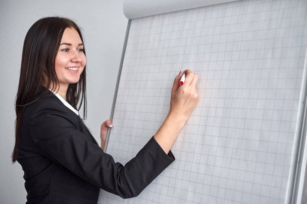 close up of woman with marker writing or drawing something on flip chart - Photo, image