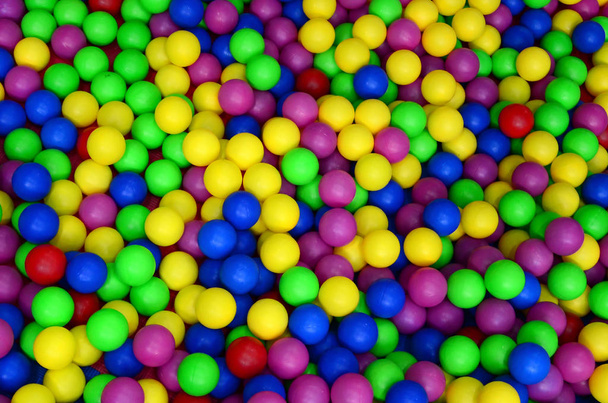 Πολλές πολύχρωμες πλαστικές μπάλες στο παιδικό ballpit στη παιδική χαρά. Εσωτερικη μοτίβο - Φωτογραφία, εικόνα