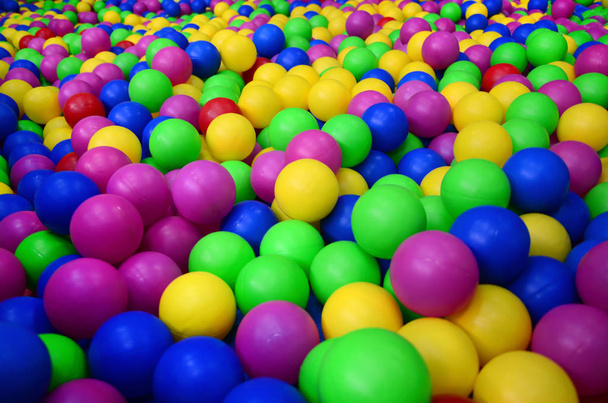 Πολλές πολύχρωμες πλαστικές μπάλες σε παιδική χαρά.  - Φωτογραφία, εικόνα