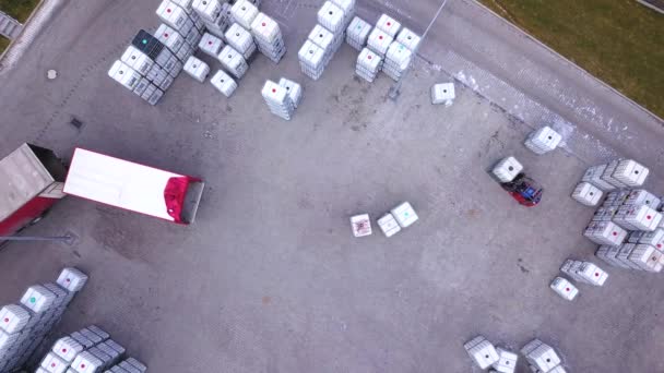 Gabelstaplerfahrer im Lager fährt zwischen Regalreihen mit Stapeln von Kisten und Verpackungsmaterial. Verladewagen. Antenne. Drohne - Filmmaterial, Video