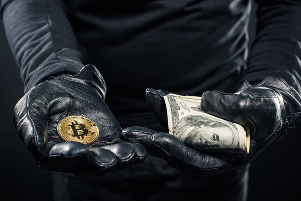 Vista de cerca de dólares y bitcoin en manos de ladrón
 - Foto, Imagen