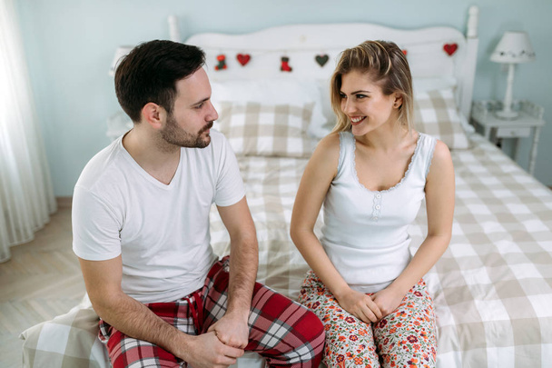 Portrait of young attractive loving couple in bedroom - Fotoğraf, Görsel