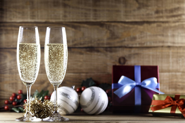 two champagne glasses with christmas balls and gifts - Фото, зображення
