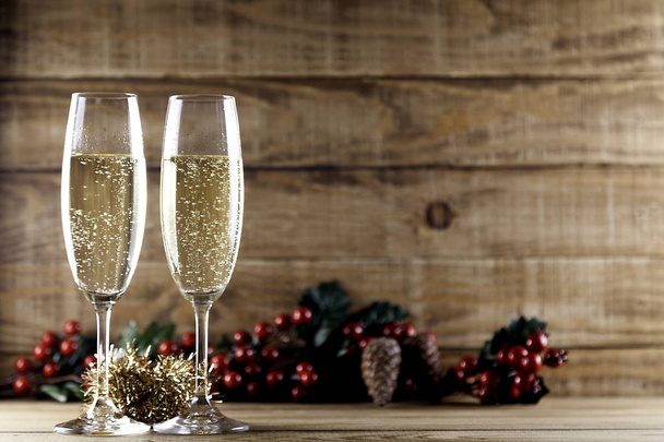 dos copas de champán con cono de pino y muérdago
 - Foto, imagen