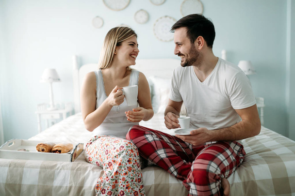 Portrait of young attractive loving couple in bedroom - Photo, image