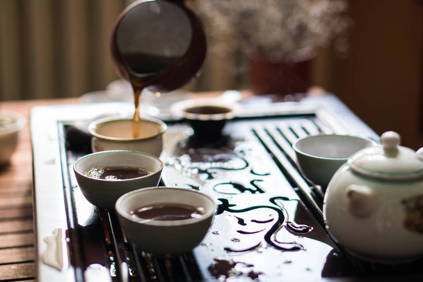 Pouring of Puer Tea from Gaiwan at Traditional Chinese Tea Ceremony. Set of Equipment for Drinking Tea - Photo, Image