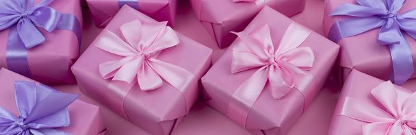 Banner διακοπών διακοσμητικά κουτιά δώρων με ροζ χρώμα σε ροζ φόντο. - Φωτογραφία, εικόνα