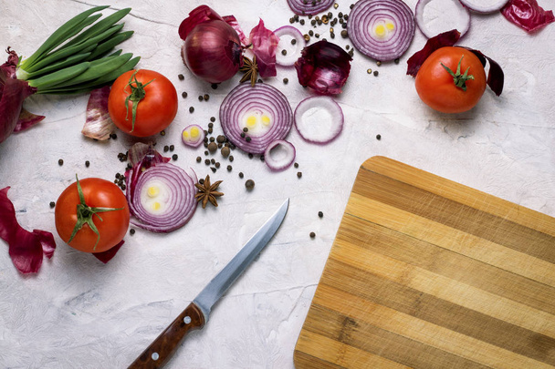 Μπαχαρικά, μαύρο πιπέρι, σκόρδο, κρεμμύδι, ξύλο κοπής, μαχαίρι και Τομ - Φωτογραφία, εικόνα