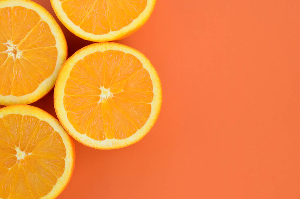 Top view of a several orange fruit slices on bright background in orange color. A saturated citrus texture image - Photo, Image
