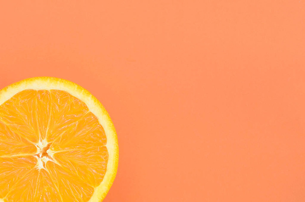 Widok z góry jeden plasterek pomarańczowy owoc na jasnym tle w kolorze pomarańczowym. Obraz nasycony tekstury owoców cytrusowych - Zdjęcie, obraz