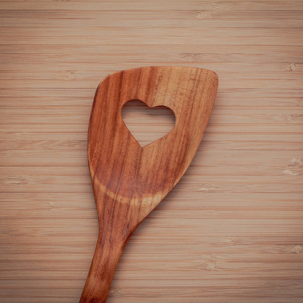 Drewniane gotowanie granica naczynia. Drewniane szpatułki z serca kształt otworu na bambusa deska do krojenia z płaskich lay i miejsce. - Zdjęcie, obraz