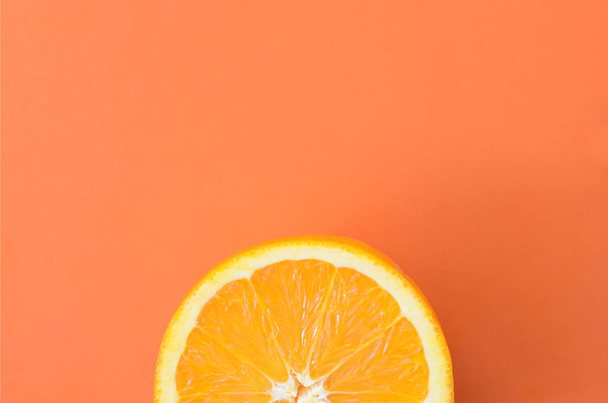 Felülnézete a egy narancssárga gyümölcs szelet narancs színű világos háttéren. A telített citrus textúrafájlt - Fotó, kép