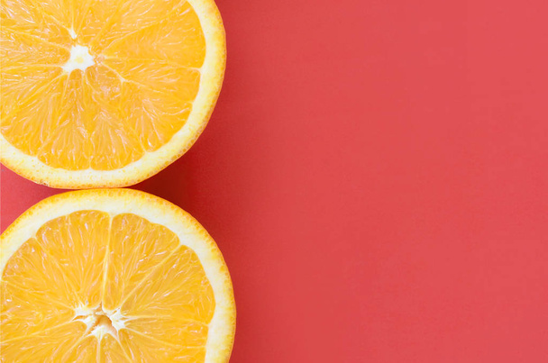 Вид зверху на кілька апельсинових фруктових скибочок на яскравому фоні червоного кольору. Зображення насиченої цитрусової текстури
 - Фото, зображення