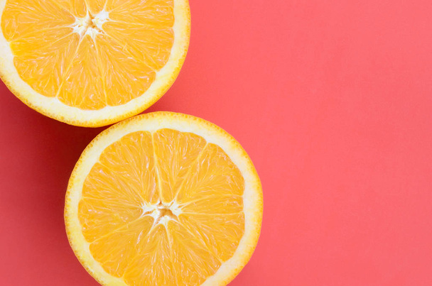 Вид зверху на кілька апельсинових фруктових скибочок на яскравому фоні червоного кольору. Зображення насиченої цитрусової текстури
 - Фото, зображення