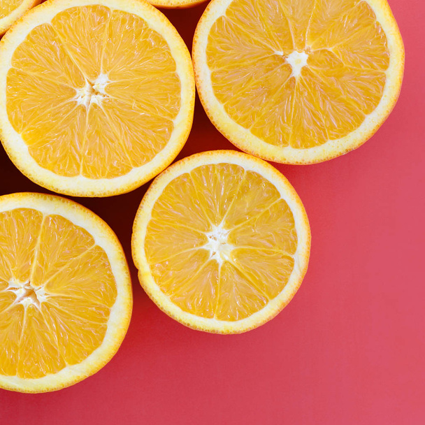 Felülnézete a több narancssárga gyümölcs szelet a világos háttér piros színű. A telített citrus textúrafájlt - Fotó, kép
