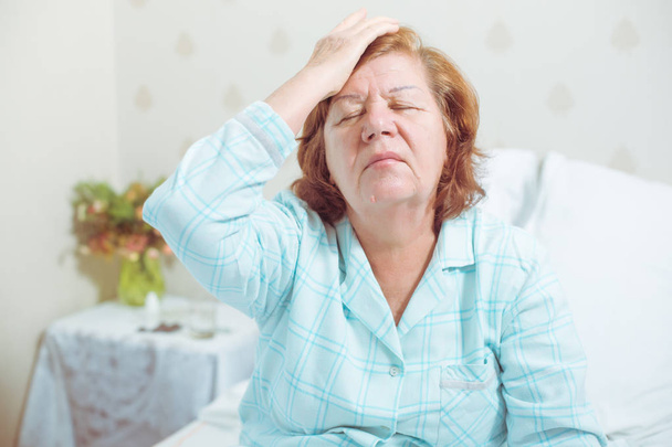 Senior mulher tem uma dor de cabeça
 - Foto, Imagem