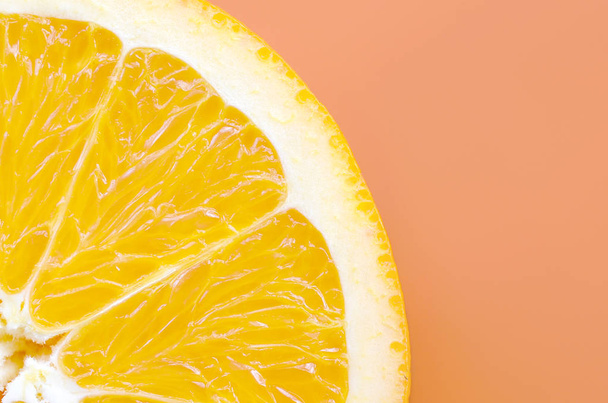 Vista superior de una rodaja de fruta naranja sobre fondo brillante en color naranja. Una imagen de textura cítrica saturada
 - Foto, Imagen