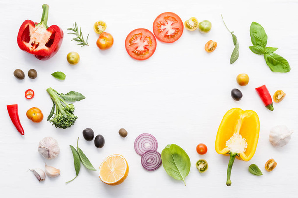 Various fresh vegetables and herbs on white background.Ingredients for cooking concept sweet basil ,tomato ,garlic ,pepper and onion with flat lay. - Foto, Imagem