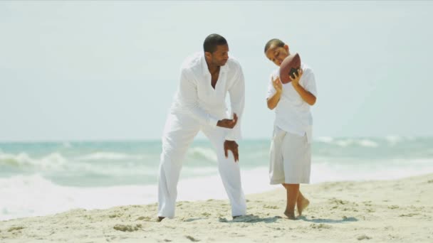 Разнообразные отец и сын весело играют в американский футбол на пляже
 - Кадры, видео