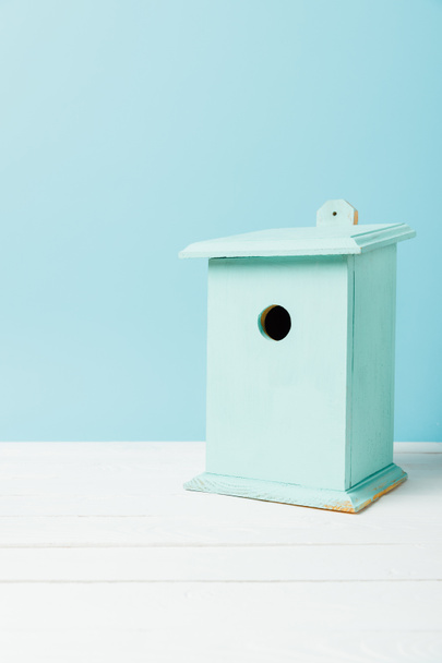 vista ravvicinata di birdhouse blu su superficie di legno isolato su blu
 - Foto, immagini