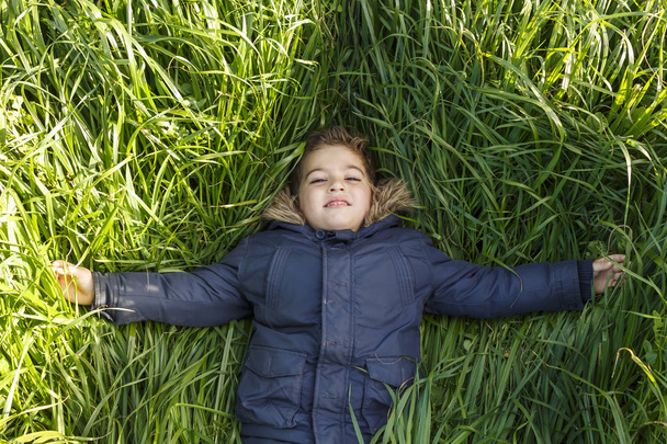 Garçon allongé sur l'herbe longue
 - Photo, image