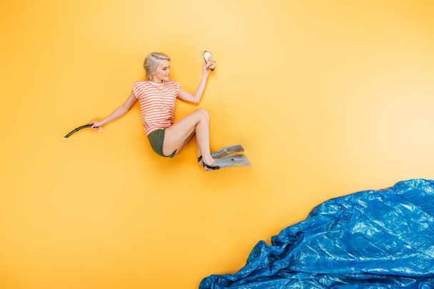 bela jovem mulher em nadadeiras pulando em imaginar o mar em amarelo, conceito de férias de verão
 - Foto, Imagem