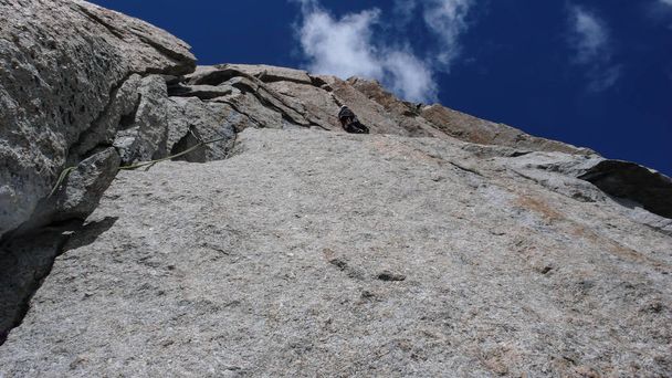 male rock climber on a steep granite route in the mountains near Chamonix in the French Alps - Photo, Image
