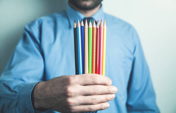 Man showing colorful pencils. - Photo, Image