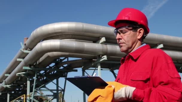 εργαζόμενος διυλιστήριο πετρελαίου με κόκκινο φόρμες - Πλάνα, βίντεο