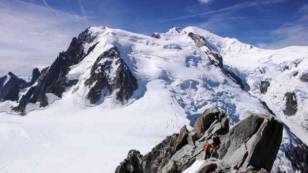 przewodnik górski i mężczyzna klienta na skalisty grzbiet w kierunku wysoki szczyt w Alpach Francuskich, w pobliżu Chamonix - Zdjęcie, obraz