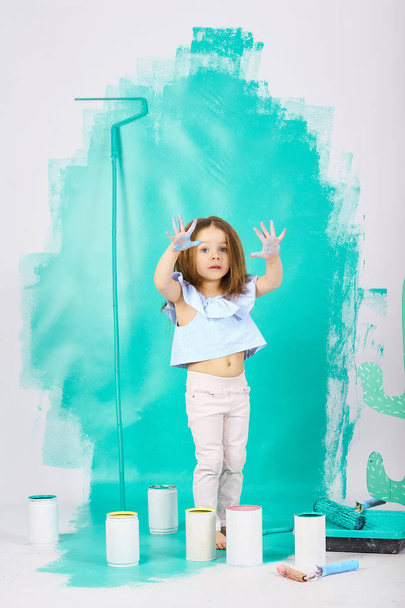 Cute little girl three years doing repairs in the apartment paints the wall  - Foto, Bild