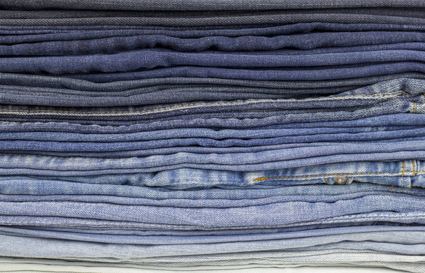 Antecedentes de calças. Denim textura ou jeans fundo, dobrado de cor clara para azul escuro
 - Foto, Imagem