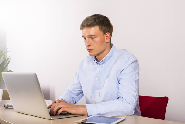 Office worker using computer on table, male caucasian young. - Photo, Image