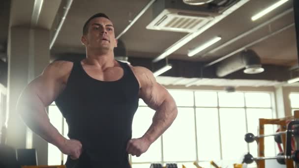 Hombre fuerte calentándose frente a un espejo en la sala de ejercicios
 - Metraje, vídeo