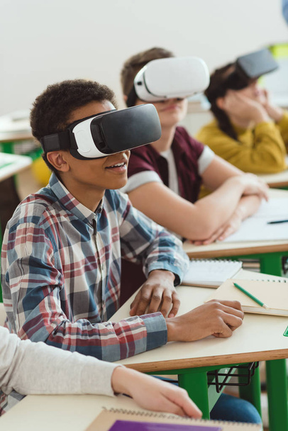 多民族の高校生が教室で仮想現実のヘッドセットを使用 - 写真・画像