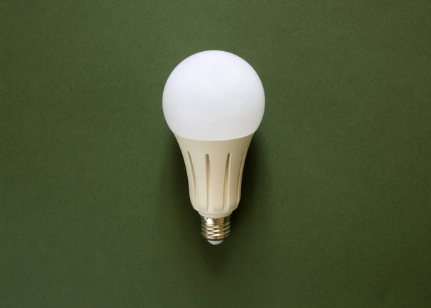 New powerful energy-saving, LED light bulb on a green background - Photo, Image