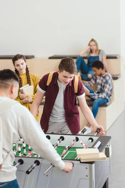 μαθητές γυμνασίου και Λυκείου παίζοντας επιτραπέζιο ποδόσφαιρο στο σχολείο - Φωτογραφία, εικόνα
