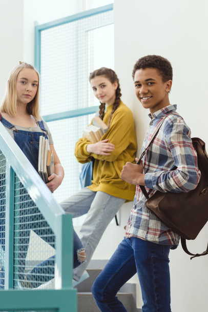 happy high school students standing on stairs at school and looking at camera - Φωτογραφία, εικόνα