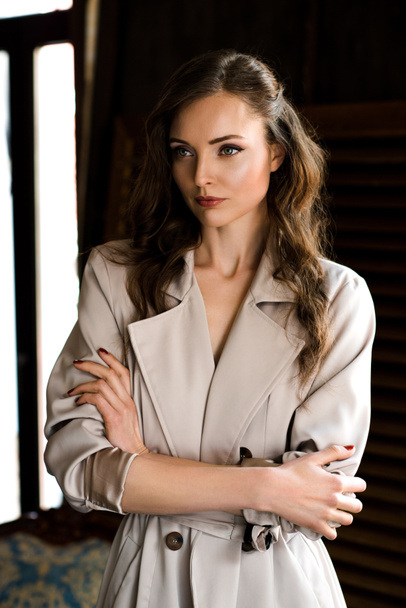 beautiful woman in trendy trench coat with crossed arms - Foto, Imagem