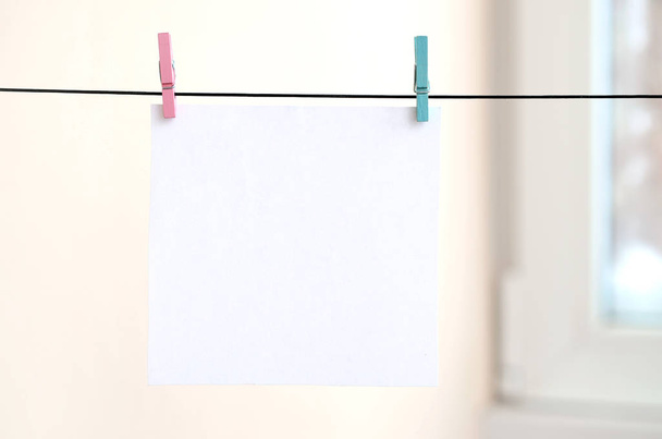 White blank cards on rope, light wall background. Creative reminder, small sheets of paper on old clothespin, memo backdrop - Photo, Image