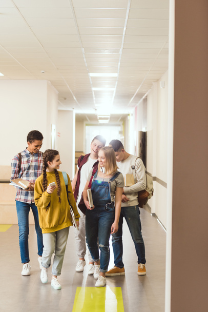 група однокласників багатоетнічної школи, які ходять шкільним коридором разом
 - Фото, зображення