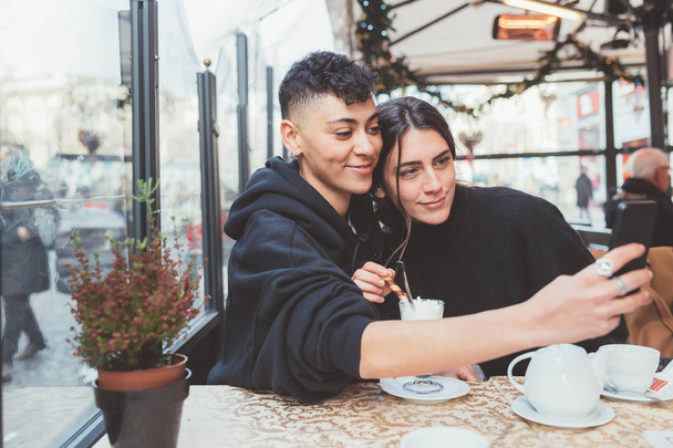 İki kadın lezbiyen çift akıllı telefon kullanarak selfie çekiyor - teknoloji, sosyal ağ, paylaşım konsepti - Fotoğraf, Görsel