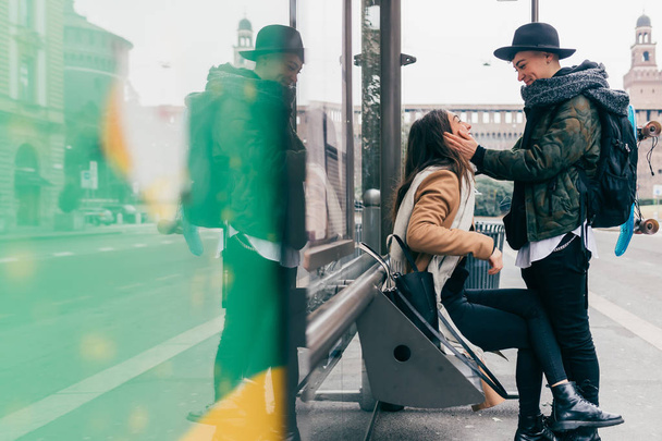 δύο γυναίκες λεσβιακό ζευγάρι κάθεται σε εξωτερικούς χώρους στάση λεωφορείου κοιτάζοντας στα μάτια - αγάπη, σχέση, έννοια μετακίνηση - Φωτογραφία, εικόνα