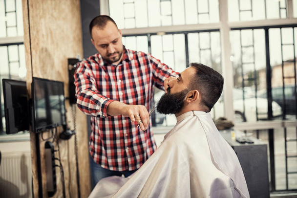 Client during beard and moustache grooming in barber shop - Foto, Bild