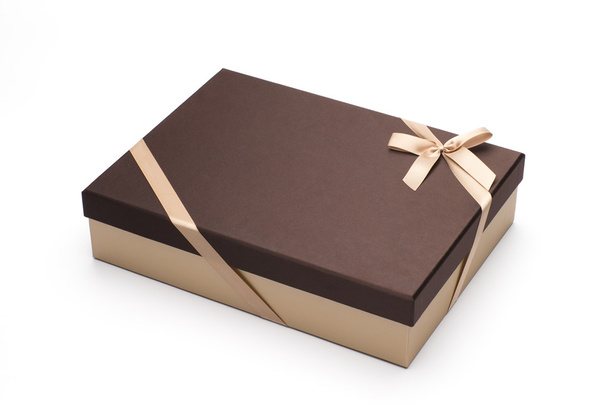 La boîte cadeau est enveloppée par un ruban jaune avec un arc, isolé sur blanc
. - Photo, image